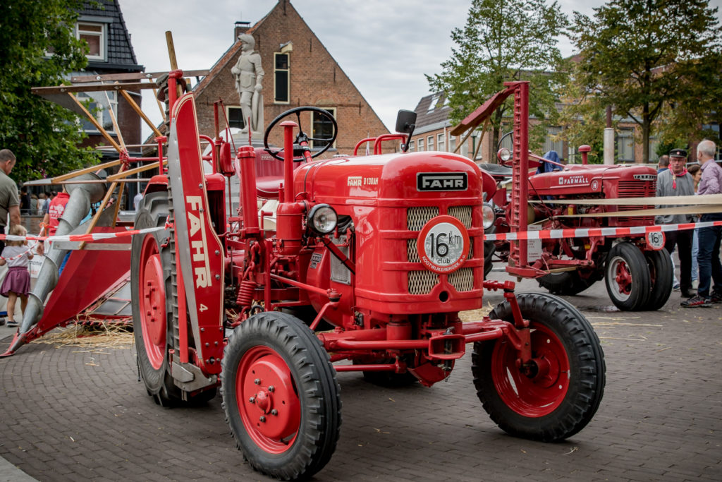 Rode oldtimer tractor met graanmaaier tijdens de Oud Veluwse Markt